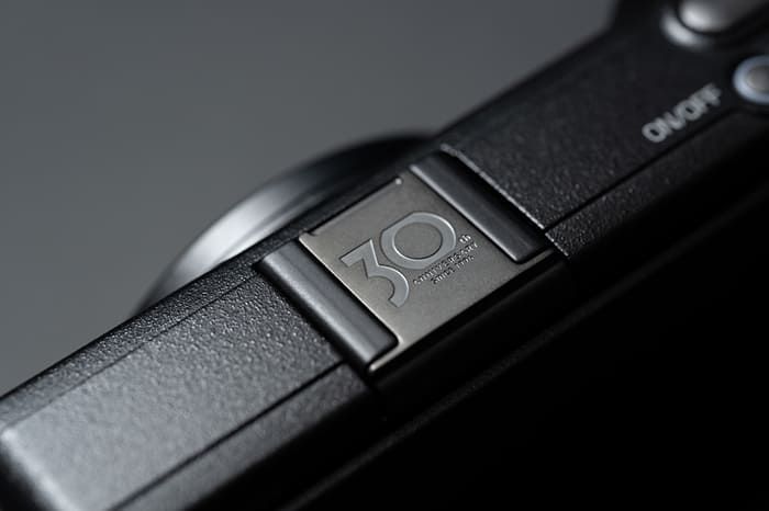 Nắp che đế gắn đèn flash bằng kim loại được khắc logo kỷ niệm 30 năm GR và hoàn thiện bằng màu xám thép